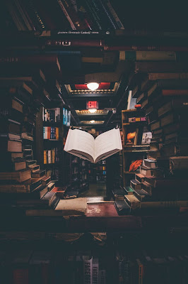 open book floating under spotlight in library